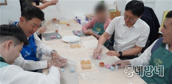 박지훈 신한은행 인천금융센터 지점장과 최진산 부지점장이 지난 1일 미추홀푸르내에서 거주 장애인들과 송편을 빚고 있다.