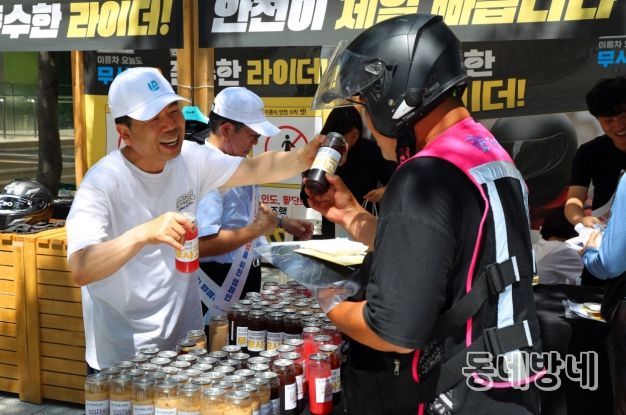 근로복지공단 박종길 이사장(왼쪽)이 지난 7월 서울 역삼역 인근에서 배달라이더들에게 시원한 음료를 나누어 주면서 고용·산재보험 거리 홍보를 진행했다.
