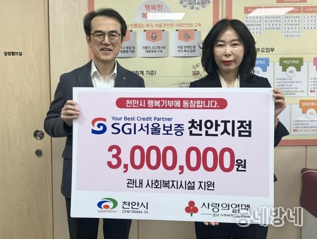 5일 윤은미 천안시 복지정책국장과 이주용 SGI서울보증 천안지점장이 성금 전달식 이후 기념촬영을 하고 있다.
